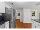 Kitchen with stainless steel refrigerator, white cabinets, and hardwood flooring at 106 Autumn Cir, Cary, NC 27518
