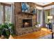 Inviting living room showcasing a stone fireplace with wood mantel and hardwood floors at 106 Autumn Cir, Cary, NC 27518