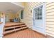 Charming patio area with wooden steps leading to a white door, offering a welcoming entrance and outdoor seating at 106 Autumn Cir, Cary, NC 27518