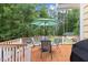 Relax on the deck with an umbrella-shaded table, white railings, and the tranquil backdrop of towering trees at 106 Autumn Cir, Cary, NC 27518
