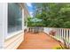 Spacious wooden deck with white railings, perfect for outdoor dining and relaxation with a view of lush greenery at 106 Autumn Cir, Cary, NC 27518