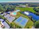 Aerial view featuring the community pool, tennis courts, playground, pond and surrounding greenery at 108 Holly Glen Ct, Holly Springs, NC 27540