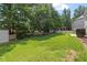 Expansive green backyard with mature trees, a charming pergola, and a well-maintained lawn for outdoor activities at 108 Holly Glen Ct, Holly Springs, NC 27540