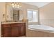 Bathroom featuring a granite countertop, a large vanity, and a soaking tub under a window at 108 Holly Glen Ct, Holly Springs, NC 27540
