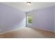 Light purple bedroom features neutral carpet and bright natural light from the window at 108 Holly Glen Ct, Holly Springs, NC 27540