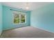 Light blue bedroom features neutral carpet and bright natural light from the window at 108 Holly Glen Ct, Holly Springs, NC 27540