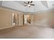 Large bedroom with ceiling fan, tray ceiling, neutral walls and carpet, and several entryways at 108 Holly Glen Ct, Holly Springs, NC 27540