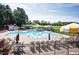 Large community pool with umbrellas, lounge chairs and a water slide, perfect for summer fun at 108 Holly Glen Ct, Holly Springs, NC 27540