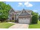 Charming two-story home with stone and gray siding, lush green lawn, and a welcoming entrance at 108 Holly Glen Ct, Holly Springs, NC 27540
