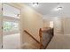 Hallway featuring a wood banister and several doorways, with natural light streaming in at 108 Holly Glen Ct, Holly Springs, NC 27540