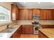Charming kitchen boasts wood cabinets, granite countertops, and stainless steel appliances at 108 Holly Glen Ct, Holly Springs, NC 27540