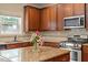 Charming kitchen boasts wood cabinets, granite countertops, and stainless steel appliances at 108 Holly Glen Ct, Holly Springs, NC 27540