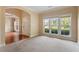 Bright living room featuring large windows, neutral carpet, and an open layout at 108 Holly Glen Ct, Holly Springs, NC 27540