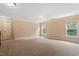 Beige carpeted loft featuring recessed lighting, neutral walls, and several windows for ample natural light at 108 Holly Glen Ct, Holly Springs, NC 27540