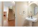 Convenient powder room with a pedestal sink and decorative mirror at 108 Holly Glen Ct, Holly Springs, NC 27540