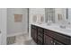 Bathroom with dual sinks, dark wood cabinets, and a large mirror at 109 Box Elder Way, Zebulon, NC 27597