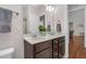 Bathroom featuring double sinks, decorative mirror, and view to the open bedroom area at 109 Box Elder Way, Zebulon, NC 27597