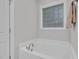 Bright bathroom featuring a large bathtub, a unique glass block window, and neutral décor at 109 Box Elder Way, Zebulon, NC 27597