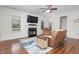 Comfortable living room with a fireplace, TV, wood floors and lots of natural light at 109 Box Elder Way, Zebulon, NC 27597