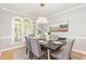 Elegant dining room with seating for six, modern chandelier, and large windows with bright natural light at 109 Murdock Creek Ct, Cary, NC 27519