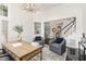 A stylish office space featuring a wooden desk, two armchairs, and a view of the staircase at 109 Murdock Creek Ct, Cary, NC 27519