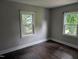 Bedroom with hardwood floors, neutral paint, and natural light from two large windows at 1102 N Guthrie Ave, Durham, NC 27703