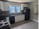 Kitchen showcasing white cabinets, black appliances and countertops, and stylish backsplash at 1102 N Guthrie Ave, Durham, NC 27703