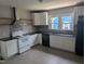 Kitchen featuring white cabinets, black countertops, stainless steel appliances and tile backsplash at 1102 N Guthrie Ave, Durham, NC 27703