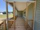 A covered porch with wooden floors, railings, and columns at 111 Hot Springs Way, Benson, NC 27504