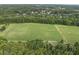 Expansive green field surrounded by lush trees, offering stunning aerial views of the community at 1133 Heritage Greens Dr, Wake Forest, NC 27587