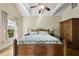 Comfortable bedroom featuring a wood bed frame, tray ceilings, and bright windows at 1133 Heritage Greens Dr, Wake Forest, NC 27587