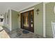 Charming home entrance showcasing a wooden front door, stone porch, and inviting light fixtures at 1133 Heritage Greens Dr, Wake Forest, NC 27587
