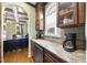 Granite countertops with stainless undercounter wine cooler, display cabinets and stainless coffee maker at 1133 Heritage Greens Dr, Wake Forest, NC 27587