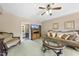 Living room with green carpet, wooden furniture, ceiling fan, and an opening that goes to the laundry room at 1133 Heritage Greens Dr, Wake Forest, NC 27587