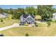 Stunning aerial view of a two-story home with a well-manicured lawn, solar panels, and a long driveway at 119 Florentino Ct, Clayton, NC 27527