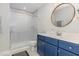 Bathroom features a blue vanity, frosted glass shower, and round mirror with gold trim at 119 Florentino Ct, Clayton, NC 27527