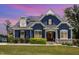 Charming two-story home featuring a blue exterior, stone accents, a well-manicured lawn, and solar panels at 119 Florentino Ct, Clayton, NC 27527