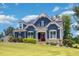 Beautiful two-story home with blue siding, white trim, a well-maintained lawn, and solar panels at 119 Florentino Ct, Clayton, NC 27527