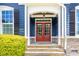 Close-up of a home's entryway showcasing a striking red double door, stone steps, and manicured landscaping at 119 Florentino Ct, Clayton, NC 27527