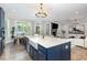 Bright kitchen with a large island, farmhouse sink, and an open view to the living room at 119 Florentino Ct, Clayton, NC 27527