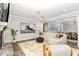 Bright living room with a stone fireplace, large sectional, and striking artwork at 119 Florentino Ct, Clayton, NC 27527