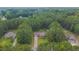 An aerial view of a charming single-story home with a long driveway nestled in a lush, green, wooded area at 1210 Bayview Ct, Franklinton, NC 27525