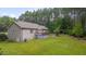 A spacious backyard featuring lush green grass, mature trees, and a charming deck perfect for outdoor relaxation at 1210 Bayview Ct, Franklinton, NC 27525