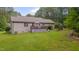 This backyard features lush green grass, mature trees, an outdoor deck, and serene natural surroundings at 1210 Bayview Ct, Franklinton, NC 27525