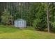 Back yard shed with double doors and a small deck surrounded by trees at 1210 Bayview Ct, Franklinton, NC 27525