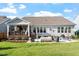 Spacious backyard featuring a covered deck, patio, and lush lawn, offering a perfect outdoor living space at 1217 Clandon Square Rd, Hillsborough, NC 27278