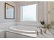 Inviting bathroom with a soaking tub, stylish fixtures, and natural light from the window at 1217 Clandon Square Rd, Hillsborough, NC 27278