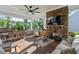 Covered outdoor patio featuring a brick fireplace, ceiling fan, and comfortable seating, ideal for relaxing or entertaining at 1217 Clandon Square Rd, Hillsborough, NC 27278