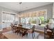 Elegant dining room features a large table, stylish light fixture and large windows with floral patterned shades at 1217 Clandon Square Rd, Hillsborough, NC 27278