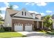 Brick home featuring a two-car garage, landscaped front yard, and a covered porch with white columns at 1217 Clandon Square Rd, Hillsborough, NC 27278